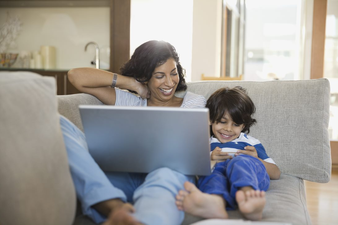 Lady and child looking at a laptop on the floor