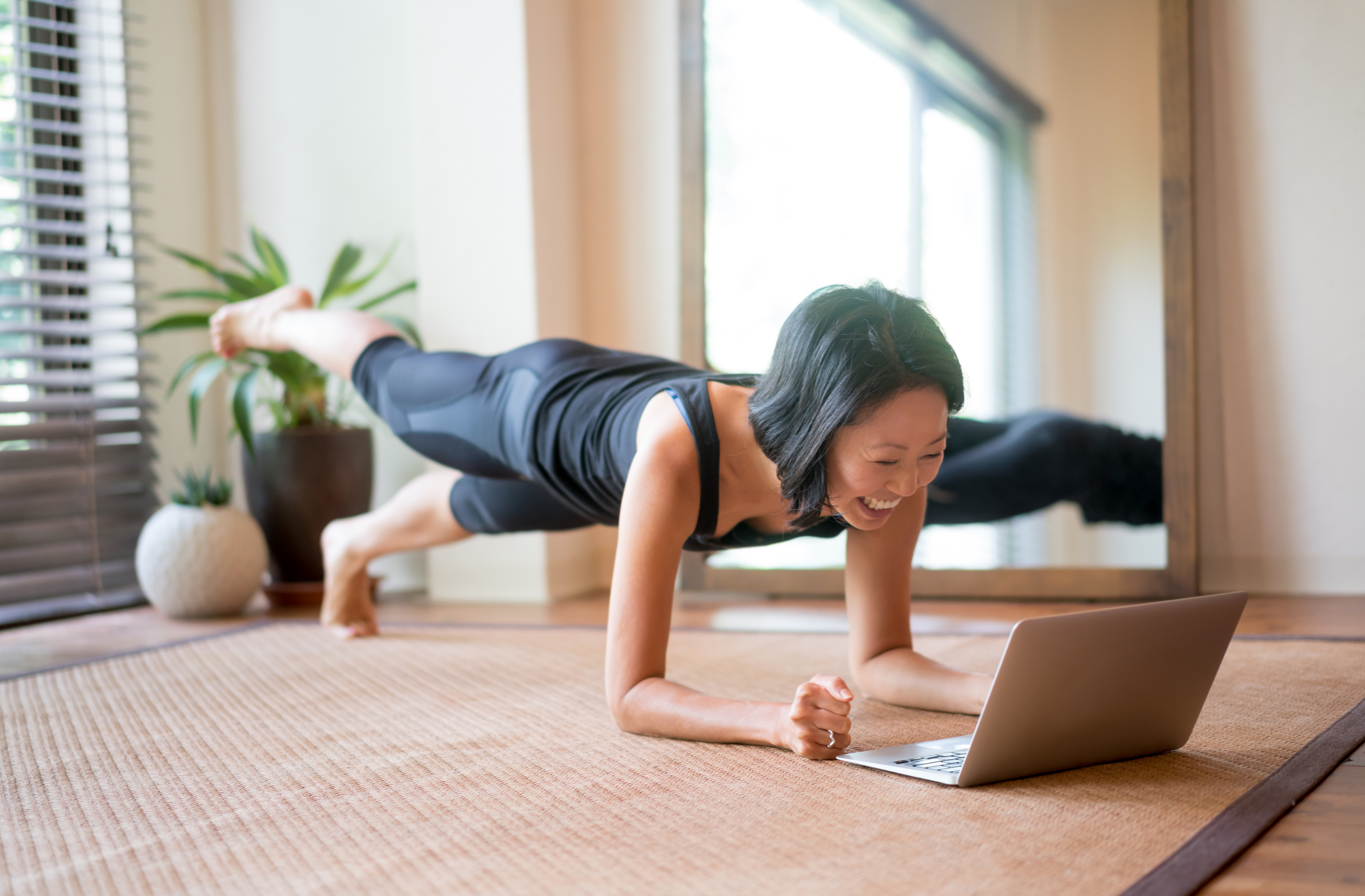 Woman doing yoga in front of laptop