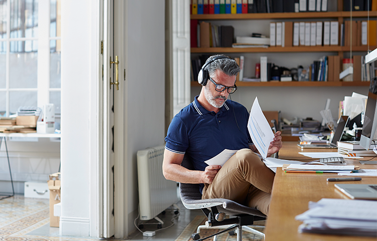 Homme assis à un bureau examinant des documents financiers